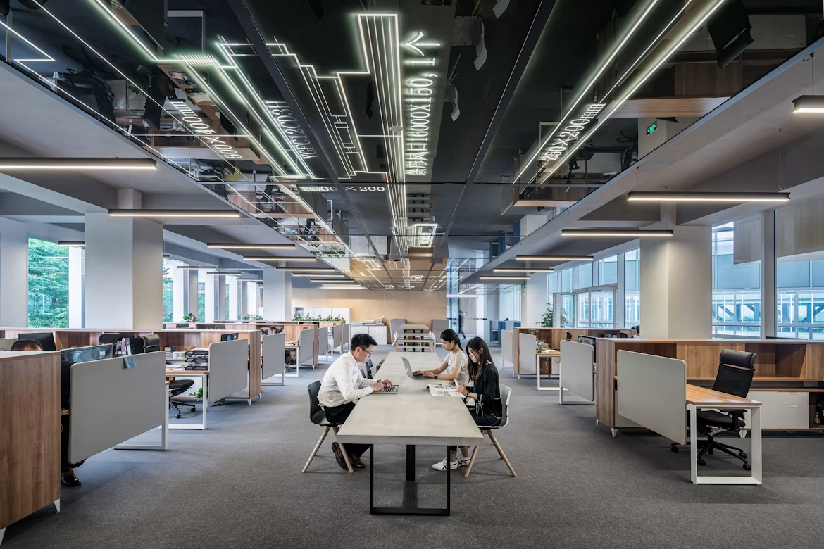 Modern office with illuminated ceiling lines and people working at a table